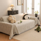 Stone Grey Wave Quilted sofa throw draped over a three-seater sofa in a bright living room, view 3