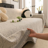Stone Grey Wave Quilted sofa throw shown across the seat and backrest of a two-seater, view 3