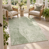 Fern green abstract terrain rug in a sunroom, framed by two cane armchairs and a round stone side table