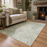 Fern green abstract terrain rug in a cottage living room, facing a stone fireplace with a lit wood stove