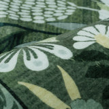 Covaba modern botanical floral rug in fern green, styled in a room setting