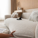 Hand smoothing the almond cream chenille cover along the front edge of the seat