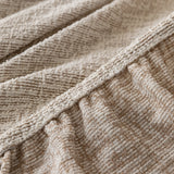 Close-up of the gathered elastic edge on the almond cream chenille sofa cover