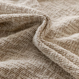 Macro of almond cream chenille fabric in soft folds showing the flecked woven texture
