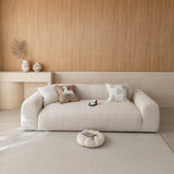 Almond cream chenille sofa cover on a three-seat sofa in a warm wood-paneled living room, front view