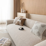 Three-quarter view of the almond cream chenille seat and backrest beside a bright window