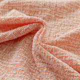 Peach clay chenille fabric in soft folds, close-up of the textured weave