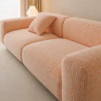 Angled close-up of the peach clay chenille seat and armrest showing the soft woven texture