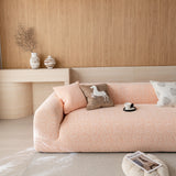 Peach clay chenille sofa cover seen at an angle from the left, styled with printed cushions