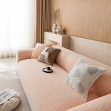 Three-quarter view of the peach clay chenille seat and backrest beside a bright window