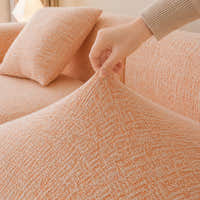 Hand pinching the peach clay chenille seat fabric, showing its stretch and woven texture