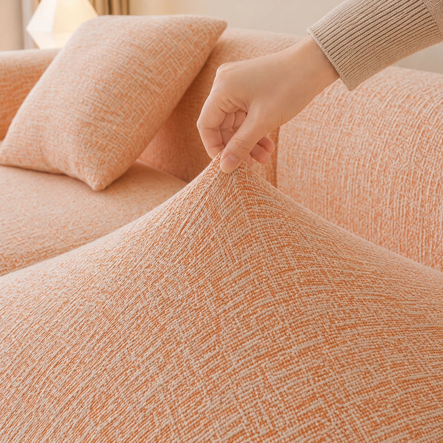 Hand pinching the peach clay chenille seat fabric, showing its stretch and woven texture