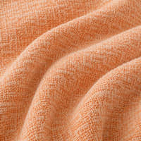 Macro of peach clay chenille fabric in soft folds revealing the woven texture