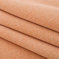 Folded stack of peach clay chenille fabric in close-up, highlighting the woven weave