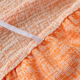 Close-up of the gathered elastic edge on the peach clay chenille sofa cover