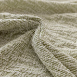 Sage veil chenille fabric in soft folds, close-up of the textured weave