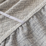 Close-up of the gathered elastic edge on the stone mist chenille sofa cover