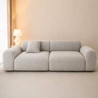 Stone mist chenille sofa cover in a warm minimalist room, styled with a cushion beside a lamp
