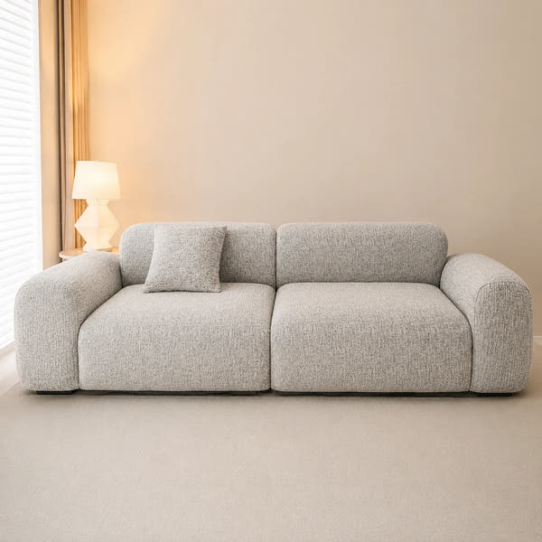 Stone mist chenille sofa cover in a warm minimalist room, styled with a cushion beside a lamp