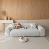 Stone mist chenille sofa cover on a three-seat sofa in a warm wood-paneled living room, front view