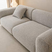 Angled close-up of the stone mist chenille seat and rounded backrest showing woven texture
