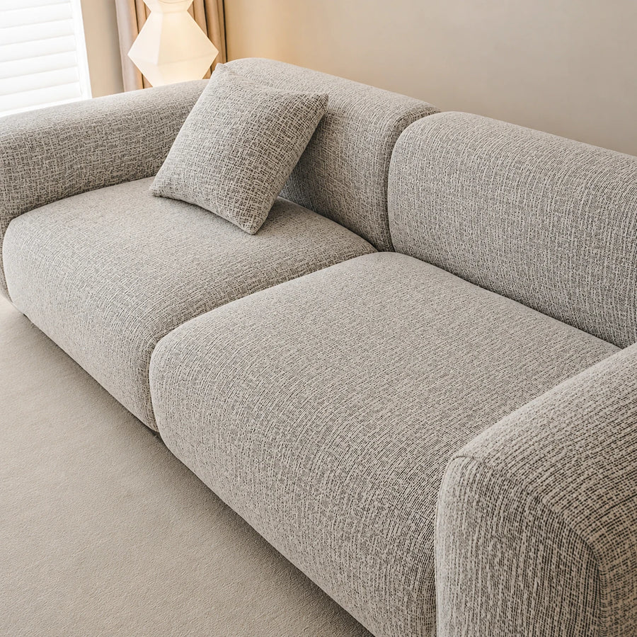 Angled close-up of the stone mist chenille seat and rounded backrest showing woven texture