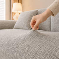 Hand pinching the stone mist chenille seat fabric, showing its stretch and woven texture