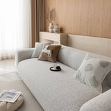 Three-quarter view of the stone mist chenille seat and backrest beside a bright window