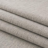Folded stack of stone mist chenille fabric in close-up, highlighting the woven weave
