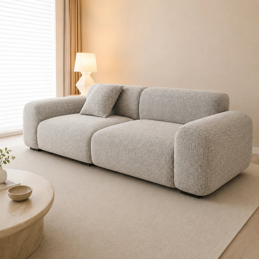 Stone mist chenille sofa cover on a plush sofa, side angle in a warm sunlit room