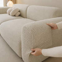 Two hands fitting the willow haze chenille cover over the rounded armrest, showing stretch fit