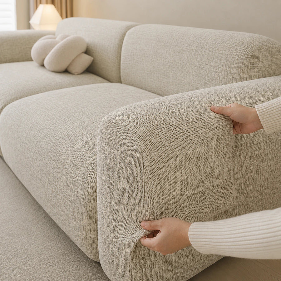Two hands fitting the willow haze chenille cover over the rounded armrest, showing stretch fit