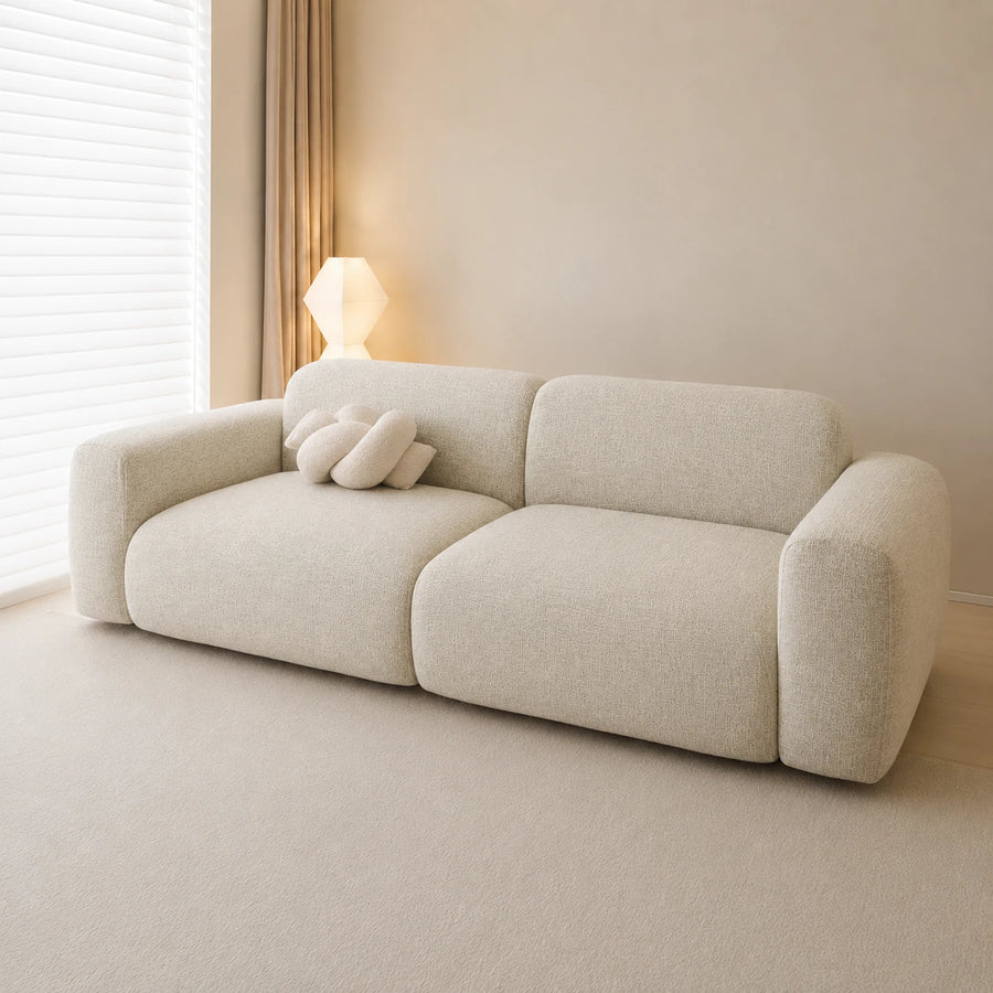 Willow haze chenille sofa cover on a plush sofa, side angle with knot cushion by the window