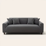 Charcoal gray corduroy stretch cover fitted on a three-seat sofa, front view on ivory backdrop