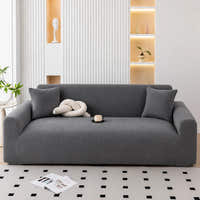 Charcoal gray corduroy sofa cover, wider angle in a bright styled room with cushion and cup