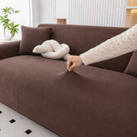 Hand stretching the cocoa brown corduroy cover across the seat, showing ribbed weave and stretch