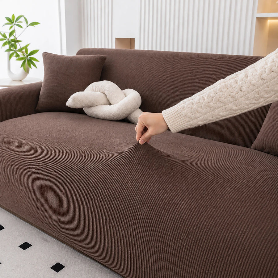 Hand stretching the cocoa brown corduroy cover across the seat, showing ribbed weave and stretch