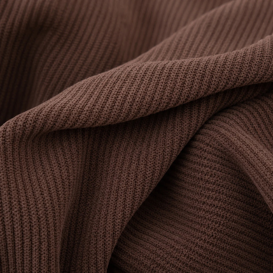 Macro of cocoa brown corduroy fabric folds revealing the soft ribbed knit texture