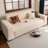Cream corduroy sofa cover in a sunlit living room with cushions and a coffee cup