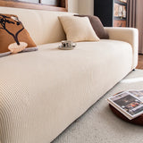 Detail of the cream corduroy cover across the seat, vertical ribbed lines and cushions