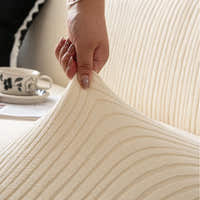 Hand stretching the cream whisper corduroy cover corner to show its elastic fit