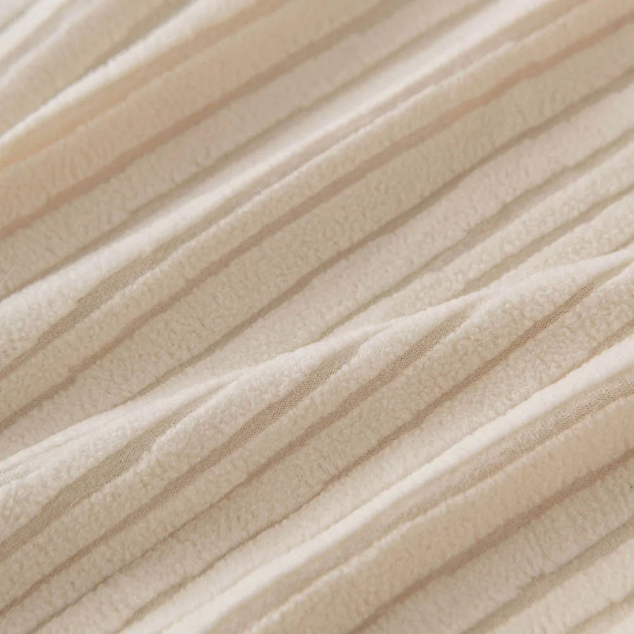 Close up of the fine ribbed texture on soft cream whisper corduroy fabric
