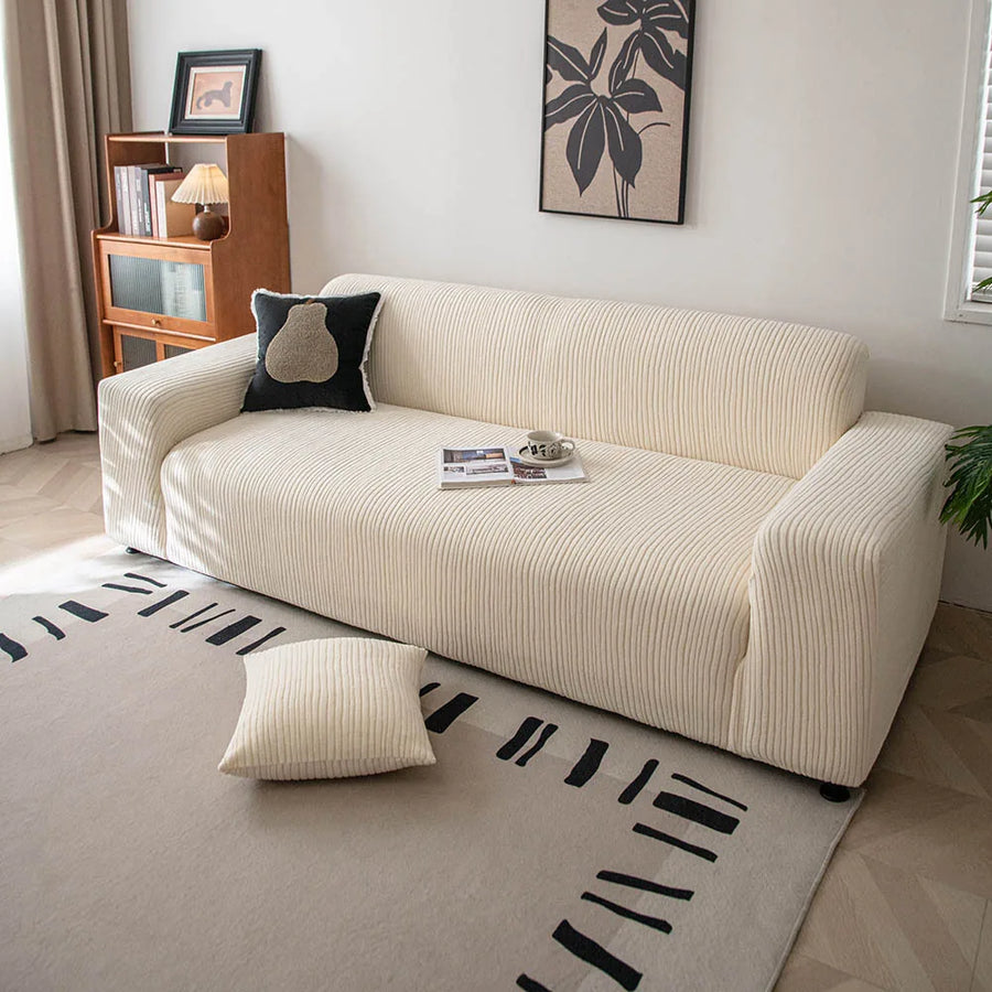 Cream whisper corduroy sofa cover styled in a sunlit room with a cushion and patterned rug