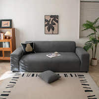 Graphite shadow corduroy stretch sofa cover in a bright living room with art and plant