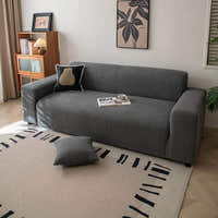 Angled view of graphite shadow corduroy sofa cover with a black cushion and coffee cup