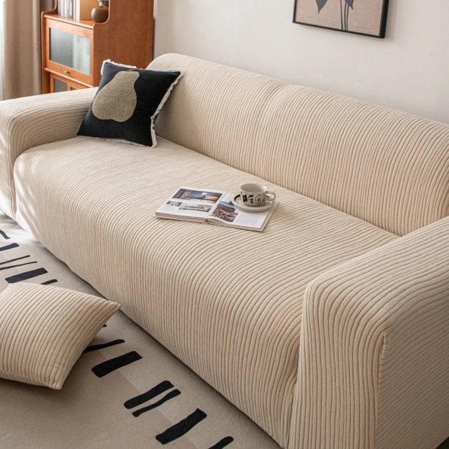 Close up of wide wale linen beige corduroy sofa cover with a book and coffee cup