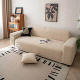Linen beige corduroy sofa cover styled in a sunlit room with a cushion and patterned rug