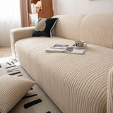 Close up angle of linen beige corduroy sofa cover with an open book and cup on the seat