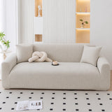 Mist gray corduroy stretch sofa cover in a bright modern room with a fluted wall and niches