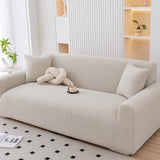 Angled view of mist gray corduroy sofa cover with a knot cushion and coffee cup